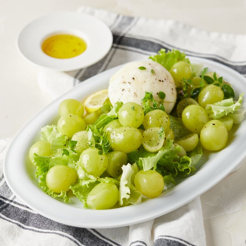 접시에 샤인머스캣과 부라타치즈, 샐러드 채소를 담아주세요.