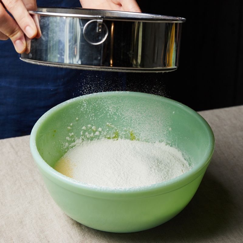 달걀물에 밀가루와 베이킹파우더를 체쳐 넣고 주걱으로 섞어주세요.