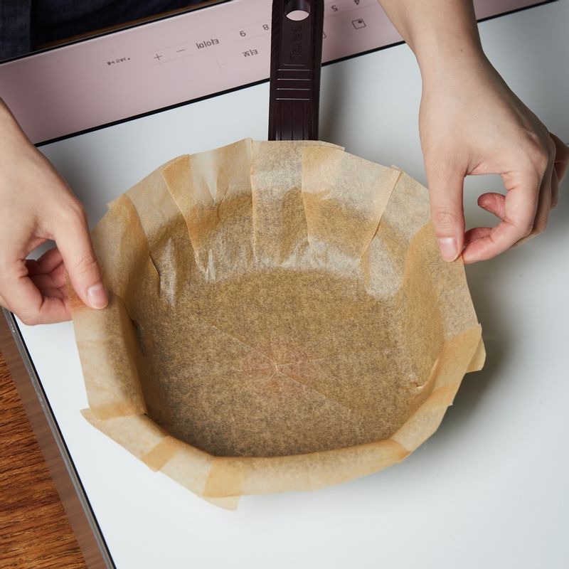 팬에 유산지를 깔고 바나나를 넣고 반죽을 부은 후 바나나를 올려주세요. 뚜껑을 덮은 후 1단에서 55분간 구워주세요.