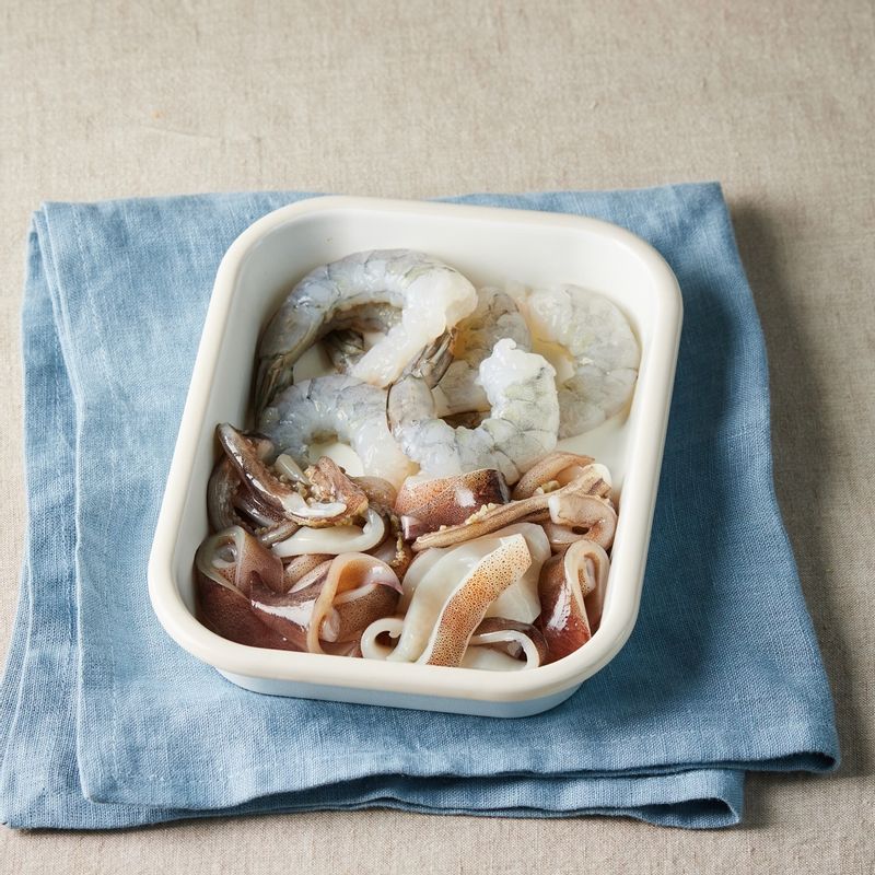 새우는 껍질을 제거하고 등부분에 칼집을 넣어주세요. 오징어는 내장을 제거한 후 둥근 링 모양으로 썰어주세요.