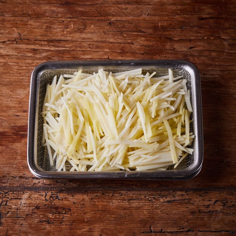 감자를 찬물에 헹군 후 채반에서 물기를 빼주세요. 볼에 감자와 베이컨, 반죽 재료를 넣고 섞어주세요.