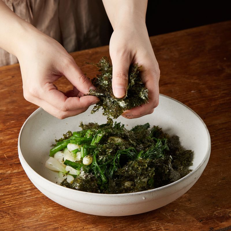 볼에 쪽파를 넣고 김을 손으로 부숴 넣은 후 양념 재료를 넣어 조물조물 무쳐주세요. 마지막에 참기름과 통깨를 뿌려주세요.
