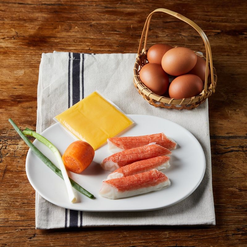 게살 치즈 달걀말이을 위한 재료 이미지로 달걀,맛살,슬라이스 치즈,당근,쪽파 등으로 구성 되어있습니다.