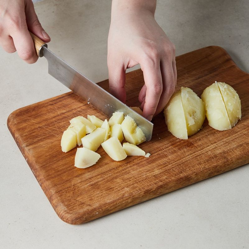 삶은 감자는 뜨거울 때 바로 껍질을 벗겨 사방 1cm로 깍뚝 썰어주세요. 쪽파는 송송 썰어주세요.