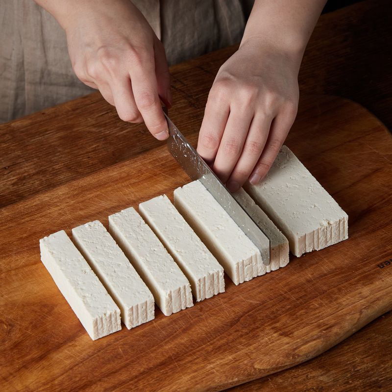 두부는 4등분 낸 후 반으로 잘라 약 2cm 두께의 도톰한 스틱 모양으로 썰어 소금을 뿌려 밑간해 주세요. 두부를 키친타월에 올려 물기를 제거해 주세요.