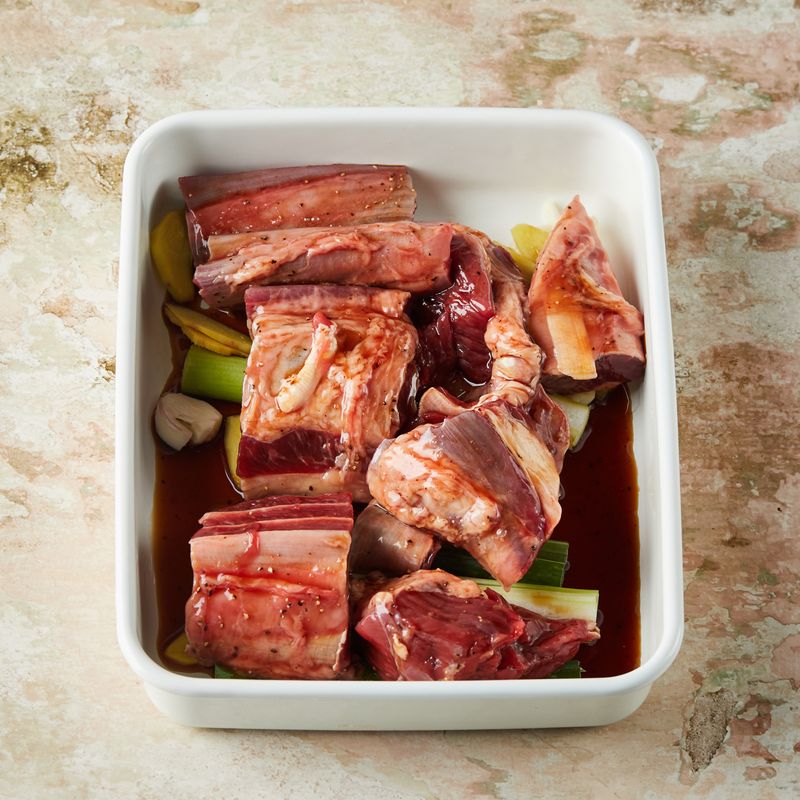 내열 용기에 대파, 생강, 마늘, 팔각, 통후추를 넣고 양념한 사태를 올려주세요.