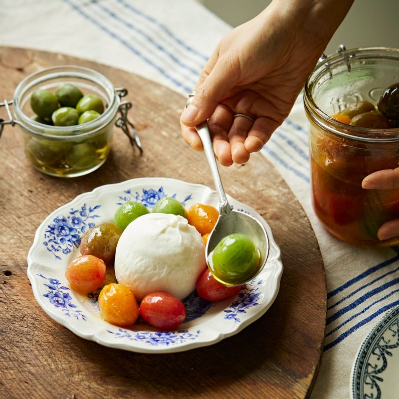 접시에 부라타치즈를 올리고 방울토마토 마리네이드를 올린 후 레몬 제스트를 뿌려주세요.