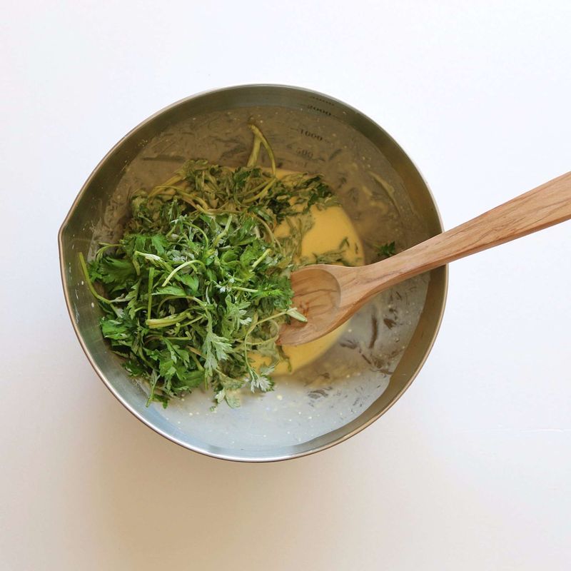 부침가루와 물, 계란을 섞어 반죽을 만든 후 쑥을 넣어주세요.