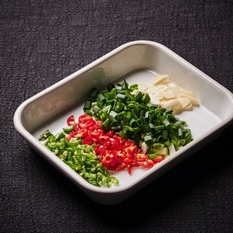 고추는 반으로 갈라 송송 썰고 쪽파는 1cm 길이로 썰어주세요. 마늘은 편을 썰어주세요.