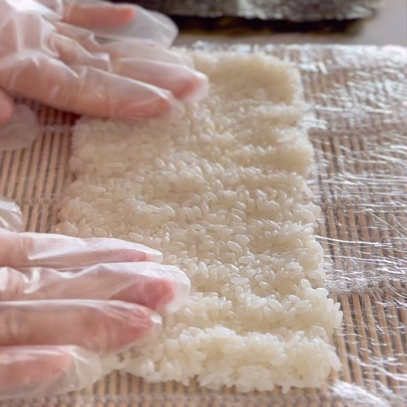 김발에 랩을 감아주고 그 위에 자른 김 사이즈대로 밥을 눌러 펴주세요.