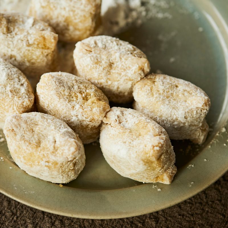 만두 겉면에 전분을 얇게 입힌 후 잔 가루를 털어주세요.