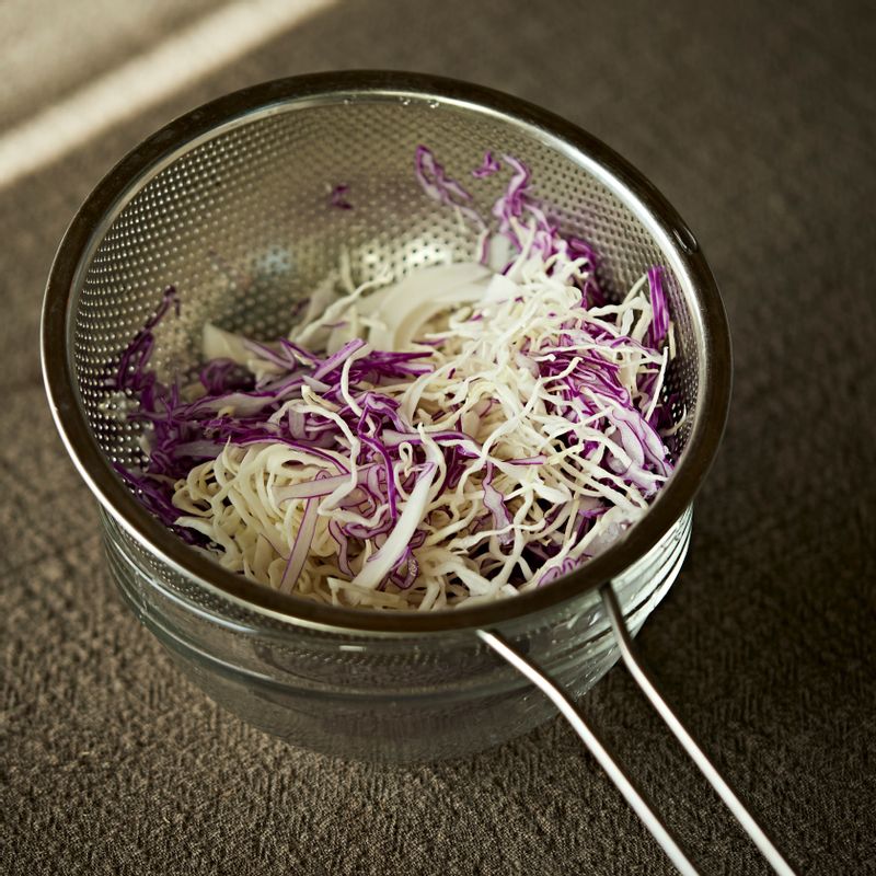 양배추는 채칼을 사용해 얇게 채를 썰어 찬물에 헹군 후 채반에 받쳐 물기를 빼주세요.