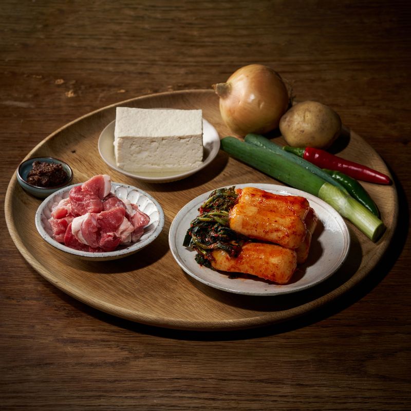 총각김치 두부 짜글이 을 위한 재료 이미지로 총각김치,김칫국물,돼지고기,감자,청홍고추 등으로 구성 되어있습니다.