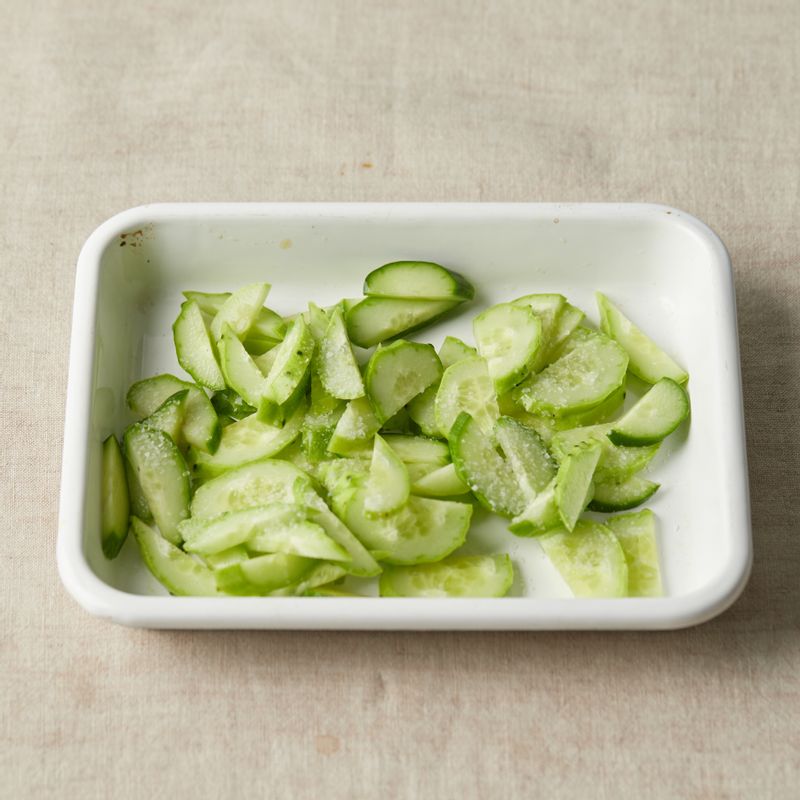 오이는 길게 2등분 하고 어슷하게 일정한 두께로 썰어주세요. 소금을 뿌린 후 5분 정도 후에 물기를 꽉 짜주세요.