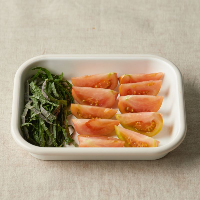 깨끗이 씻은 토마토는 꼭지를 떼고 웨지 모양으로 잘라주세요. 깻잎은 가늘게 채를 썰어주세요.