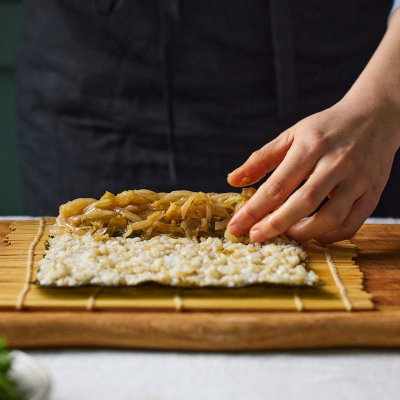 김의 거친 면을 위로 해서 밥을 고르게 편 후 묵은지, 오이, 참치를 올려 김밥을 말아 주세요.
(tip. 앞쪽 끝부분을 잡고 살살 눌러 가며 말아주세요. 너무 꾹 누르면 속재료의 물기가 빠져 나올 수 있어요)