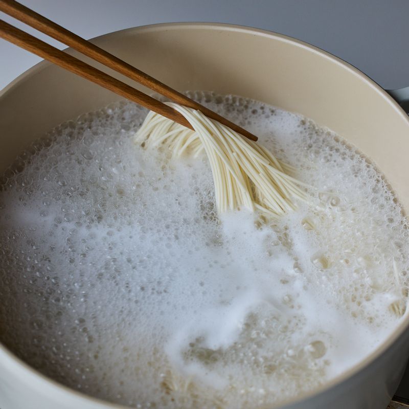 끓는 물에 소면은 넣고 저어가며 끓여주세요. 거품이 올라오면 찬물 1컵을 세 번에 나눠 넣어가며 소면을 삶아주세요.