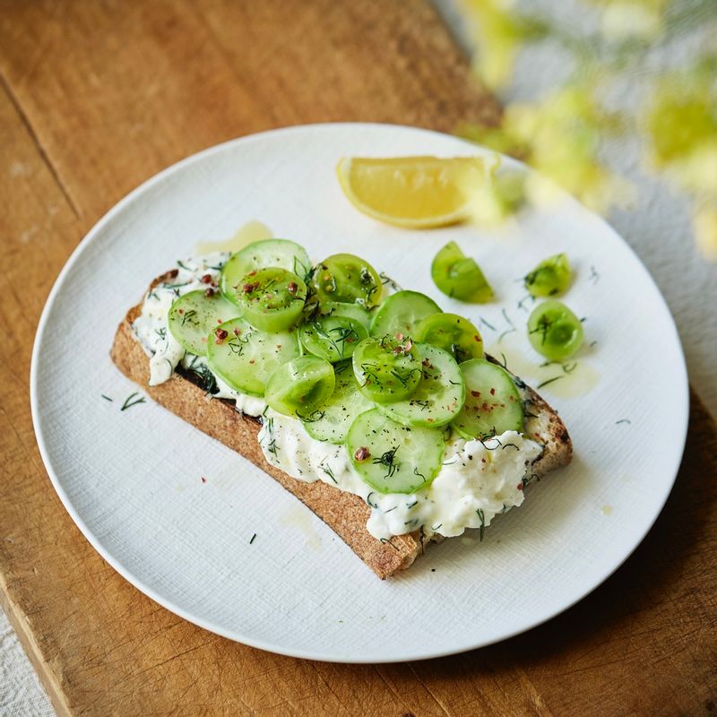 빵 위에 섞은 재료를 얹고 오이와 딜, 크러쉬드 레드페퍼와 소금, 후춧가루를 뿌려 완성해주세요.