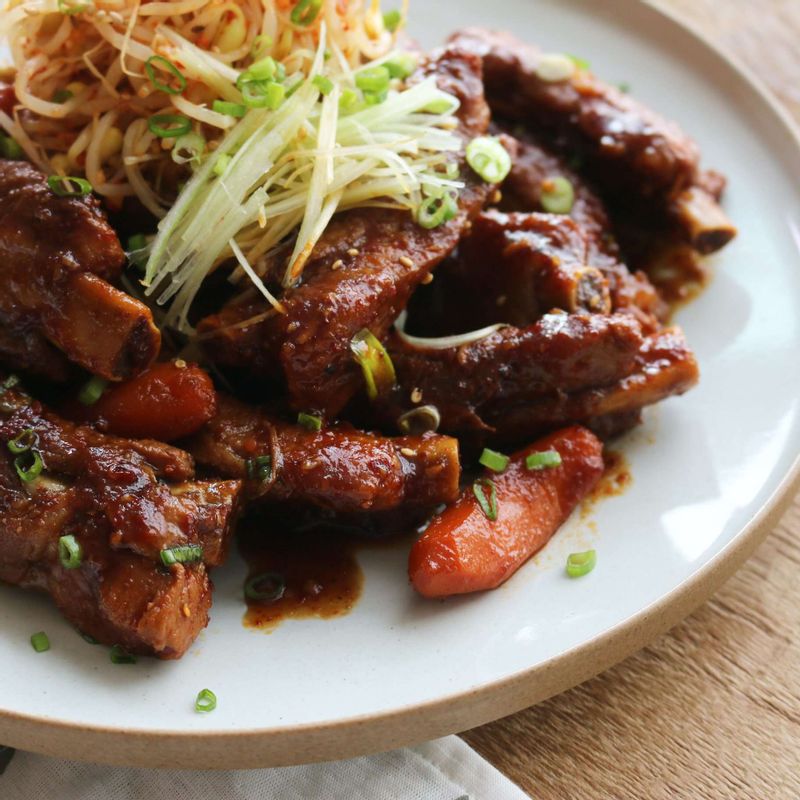 오목한 그릇에 등갈비를 담고 양념한 콩나물과 대파채와 송송 썬 실파와 깨를 뿌려주세요.