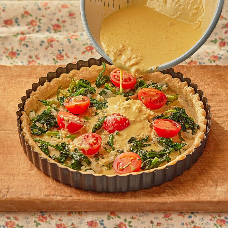 파이지에 시금치와 방울토마토를 올리고 키쉬 반죽을 부어주세요.