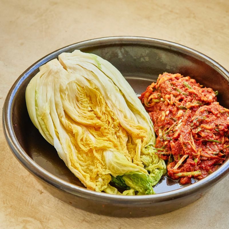 절여진 배추에 김치 양념을 적당량씩 넣어 속을 채워주세요.