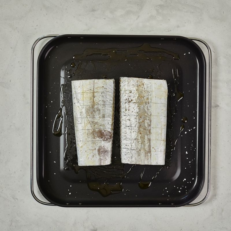 갈치는 키친타올로 물기를 제거한 후, 칼집을 넣고, 소금을 뿌려 간을 해주세요. 베이킹 트레이에 오일을 적당량 뿌린 후, 갈치를 올려 한번 더 오일을 뿌려주세요.