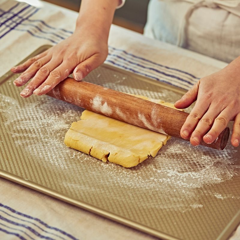 반죽이 준비 되면 덧밀가루를 뿌려가며 두께가 0.3cm가 되도록 밀대로 밀어주세요. 반죽을 타르트틀에 올린 후 모서리 부분을 손가락으로 살살 눌러 틀에 밀착시키고 여분의 반죽은 떼어내 주세요.
(tip. 덧밀가루는 강력분으로 사용해 주세요)
(tip. 강력분을 사용하는 이유는 밀가루 입자가 박력분보다 커서 뭉침이 덜하고 반죽에 덜 스며들기 때문이에요)