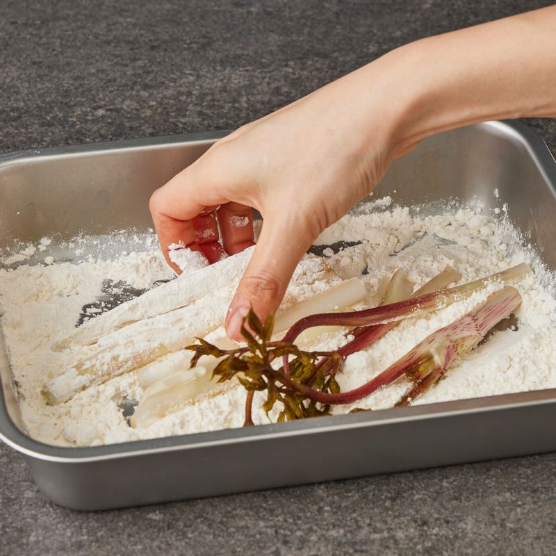 볼에 튀김옷 재료를 넣고 젓가락으로 가볍게 섞어주세요. 물기를 제거한 두릅에 튀김가루를 얇게 묻혀 털어 낸 후 섞어 놓은 튀김 반죽을 입혀주세요.