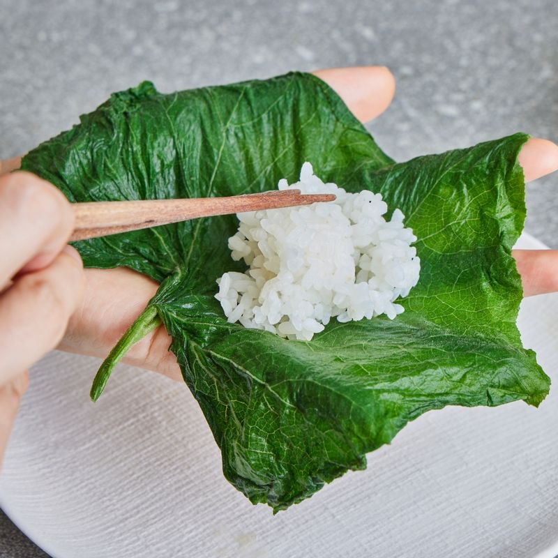 호박잎 위에 밥을 한술씩 떠서 올린 뒤 쌈장을 적당량 넣고 돌돌 말아 쌈밥을 만들어주세요.