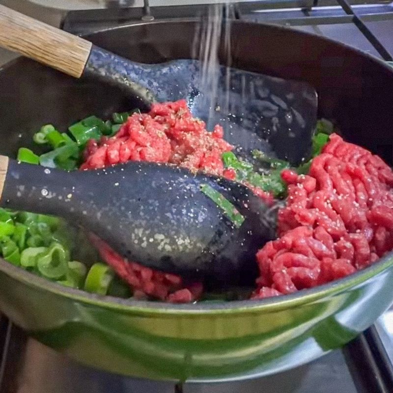 팬에 올리브오일을 두르고 대파를 중불에서 30초 정도 먼저 볶아주세요. 쇠고기를 넣어 중불에서 3분 정도 볶아주세요.