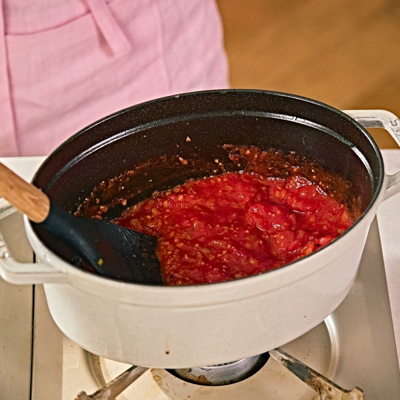 홀토마토와 설탕을 넣고 저어주다가 월계수 잎, 소금을 넣고 10분간 뭉근하게 끓여주세요.