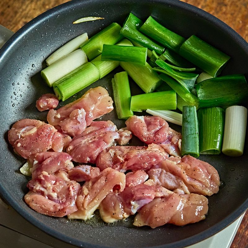 대파를 팬의 한쪽으로 밀어두고, 닭고기를 넣어 앞뒤로 노릇하게 익혀주세요.