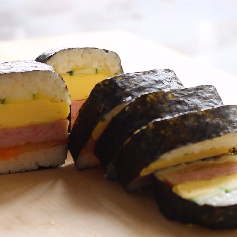 김을 반으로 2등분하고, 무스비를 김으로 돌돌 감싸 먹기 좋은 크기로 잘라주세요.