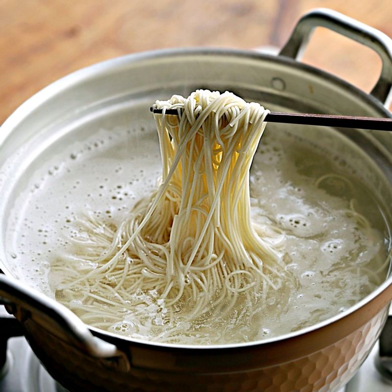 끓는 물에 소면을 펼쳐 넣고 면끼리 달라붓지 않도록 저어주세요. 물이 끓어오르면 찬물을 2~3회 반복해서 부어 국수를 삶아주세요. 흐르는 찬물에 소면을 여러 번 씻어 전분기를 없애고 채반에 밭쳐 물기를 빼주세요.