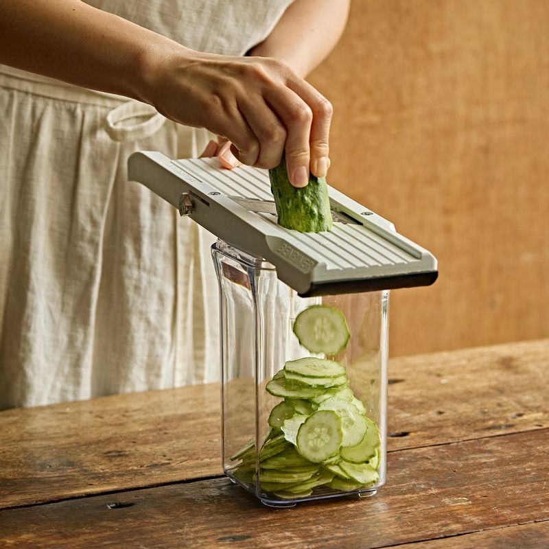 깊은 통에 오이와 양파를 채칼로 얇게 슬라이스해주세요. 당근은 채칼이나 칼로 가늘게 채를 썰어 통에 바로 넣어주세요.