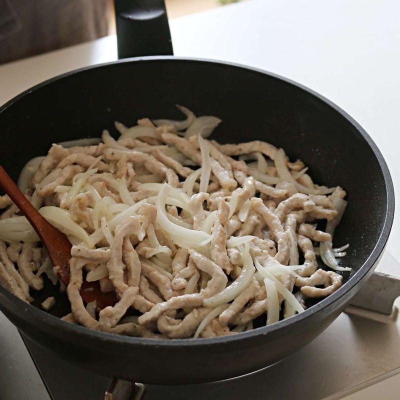 달군 팬에 식용유를 넉넉히 넣어 돼지고기를 볶다가, 고기가 익으면 양파를 넣고 1분간 볶아주세요.