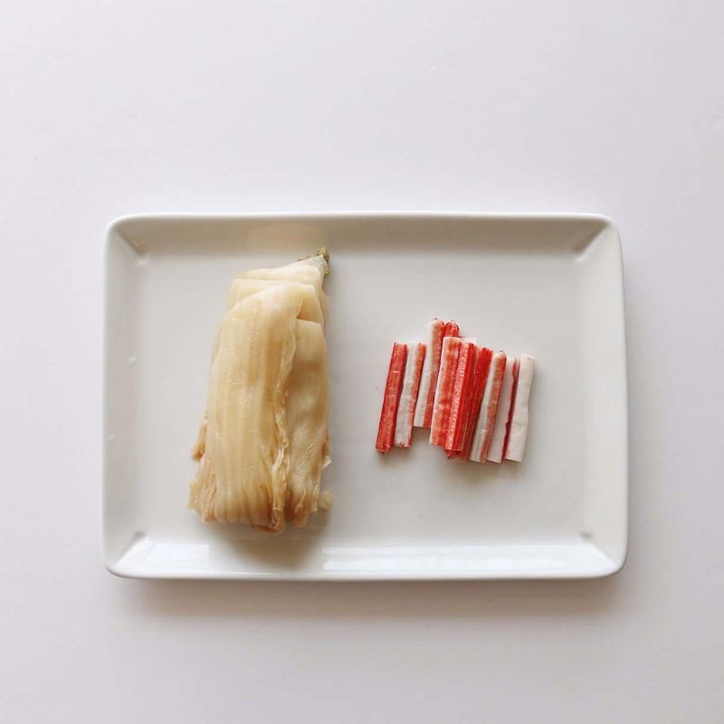 묵은지는 김칫소를 잘 털어내고 깨끗이 씻어 물기를 제거해주세요.
맛살은 2등분 하고 6센치 길이로 썰어주세요.