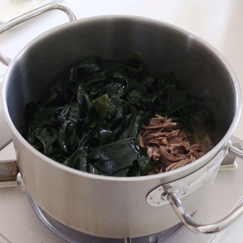 냄비에 참기름을 두르고 밑간을 한 쇠고기와 미역을 넣어 2~3분 정도 볶아주세요.