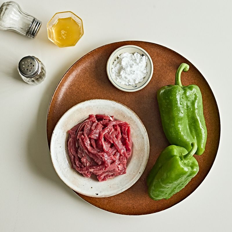 소고기 피망 볶음 을 위한 재료 이미지로 얇게 썬 소고기(잡채용 소고기),피망,다진 마늘,생강 가루,소금,후춧가루 등으로 구성 되어있습니다.