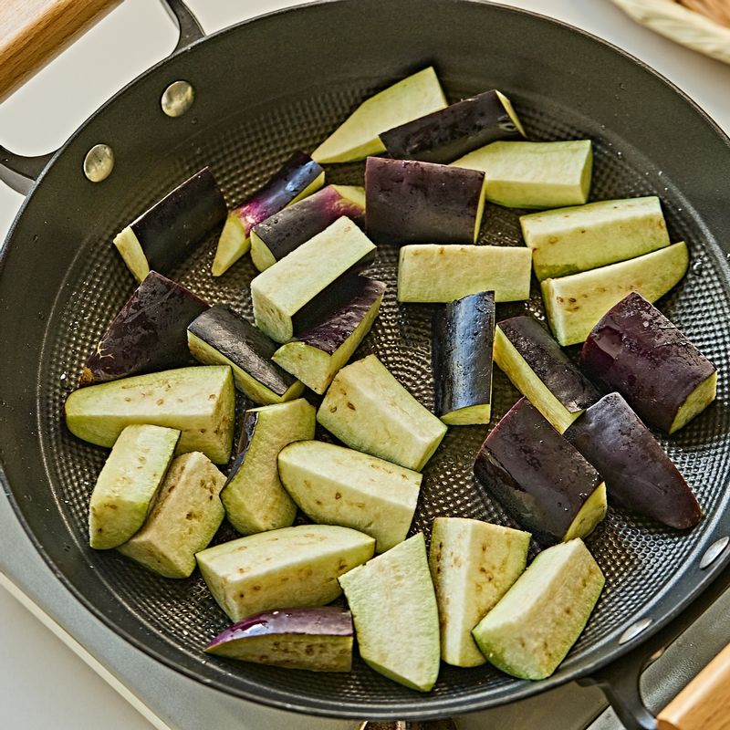 팬에 식용유를 두르고 가지를 넣어 노릇하게 구운 후 피망, 대패삼겹살을 넣고 강불로 1분간 볶다가 중불로 줄여 양념을 붓고 졸이듯 2~3분 더 볶아주세요.