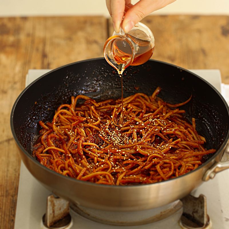 양념이 고루 섞이도록 2분 정도 버무리고 불을 끈 후 참기름과 통깨를 뿌려주세요.
(오징어채는 오래 볶으면 질겨질 수 있으니 약한불에서 짧은 시간 동안 빠르게 볶아주세요.)