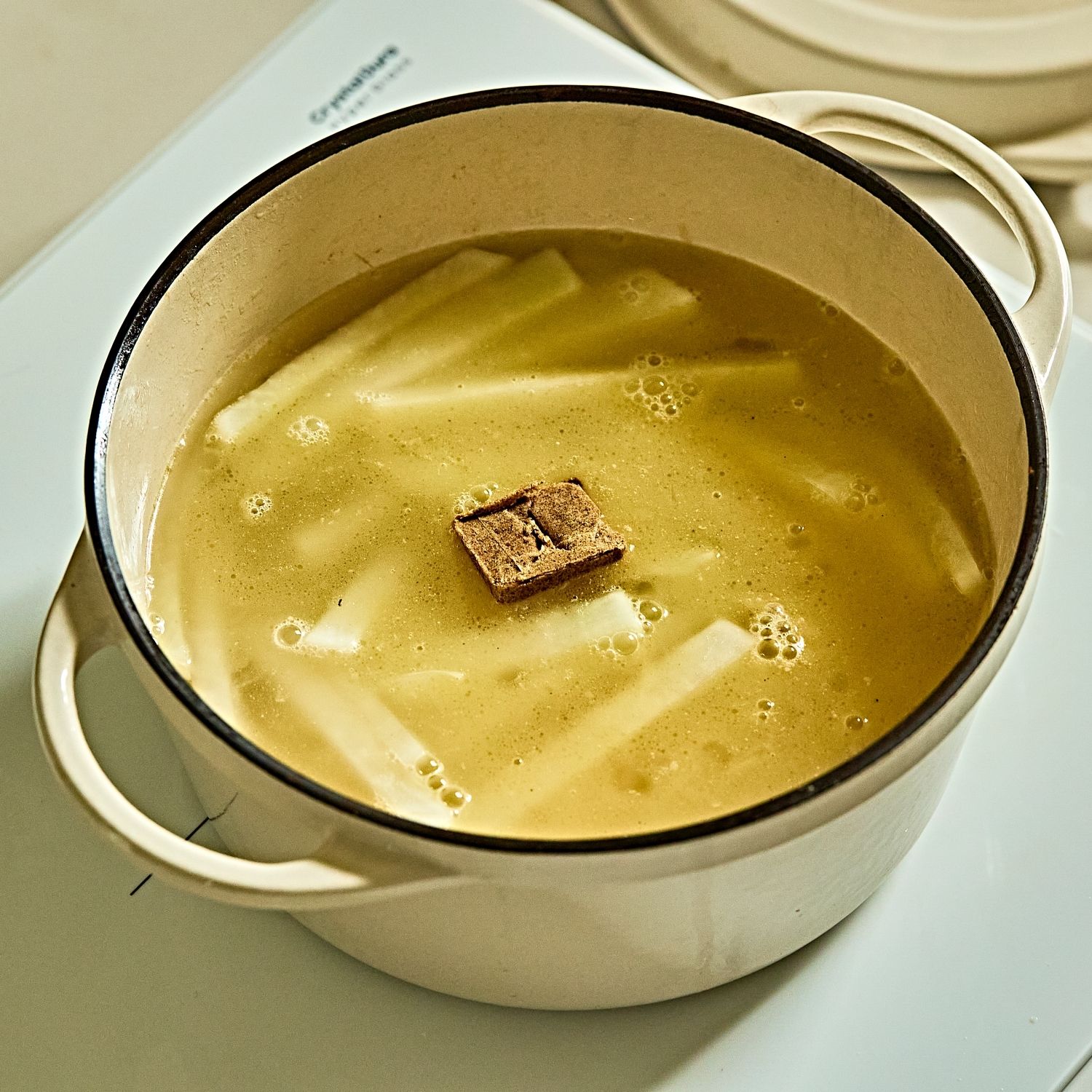 물과 스톡을 넣고 무가 푹 익도록 끓여주세요. 