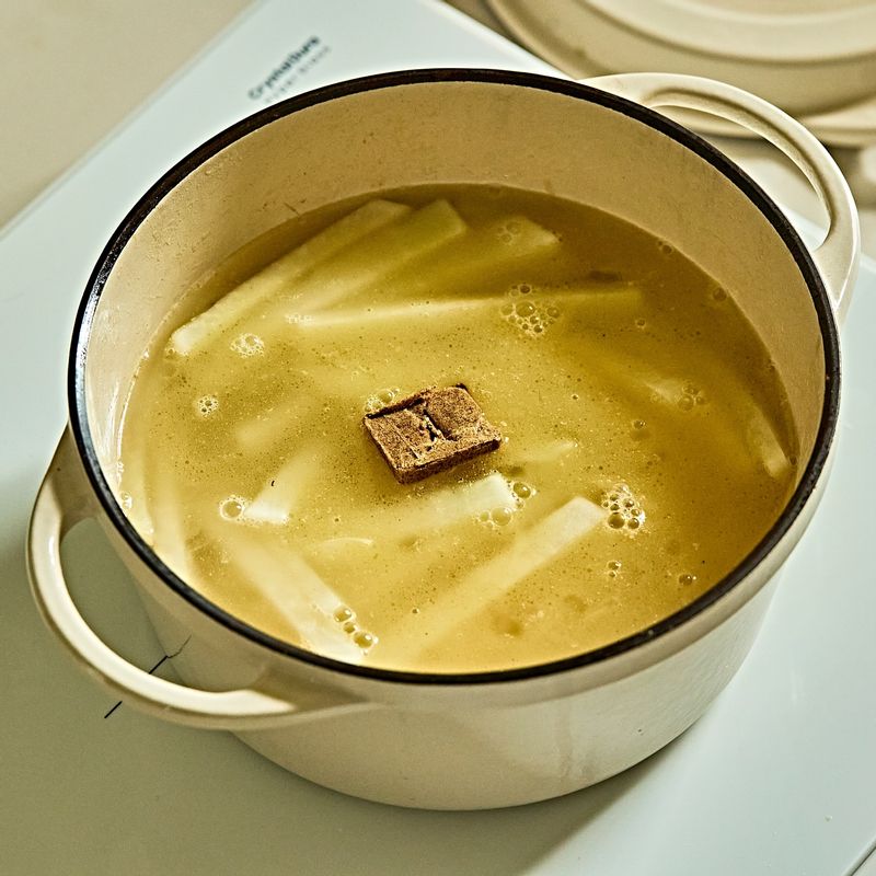 물과 스톡을 넣고 무가 푹 익도록 끓여주세요.