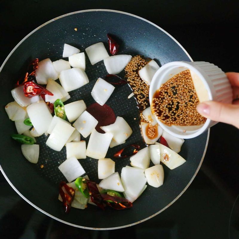 팬에 기름을 두르고 강불에서 양파와 청양고추, 마른 홍고추를 볶다가 향이 올라오면 소스의 1/2 분량을 넣어 조려주세요.