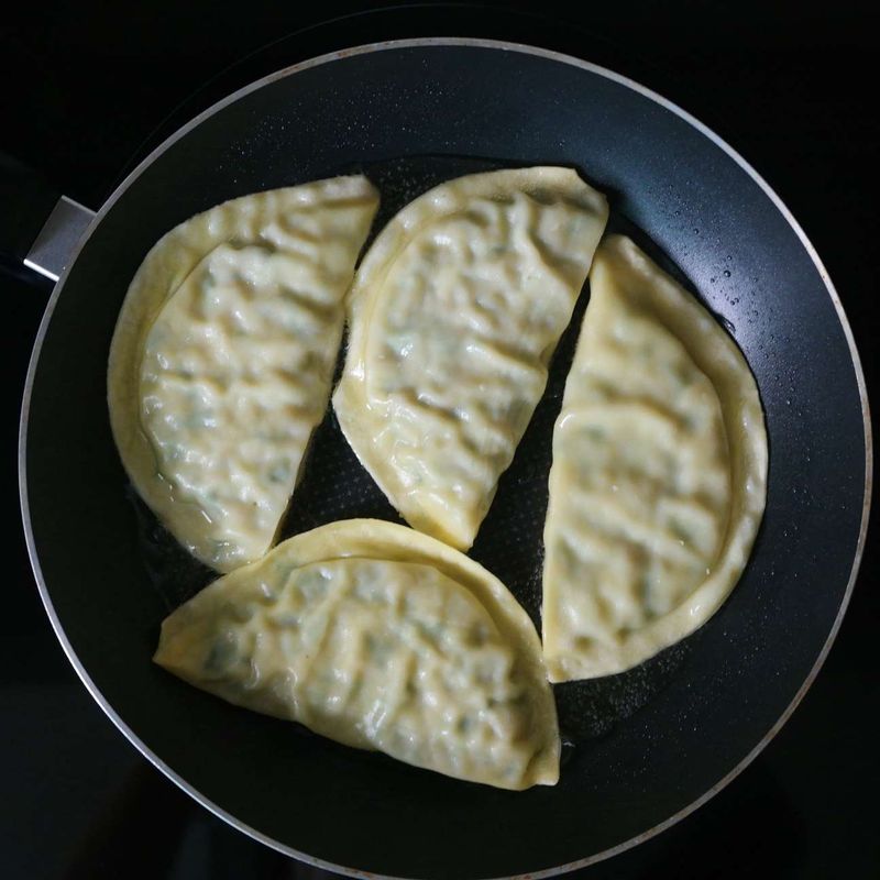 달군 팬에 기름을 두르고 만두를 올려 노릇하게 구워주세요. 키친타월에 올려 기름을 뺀 후 먹기 좋게 잘라주세요.