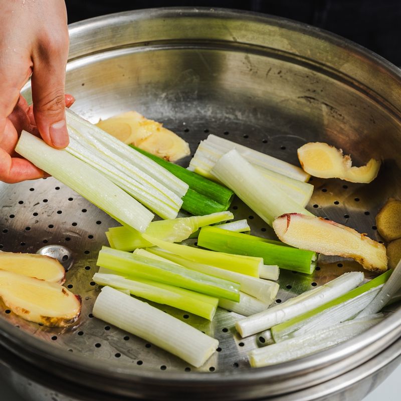 찜기에 슬라이스한 생강, 대파를 깔고 참돔을 올려주세요.
(손질tip. 참돔은 칼등이나 비늘 제거 도구로 비늘을 긁어낸 후, 가위로 지느러미와 꼬리를 제거해 주세요. 배를 갈라 내장과 아가미를 제거하고 깨끗이 씻어 사용해 주세요)