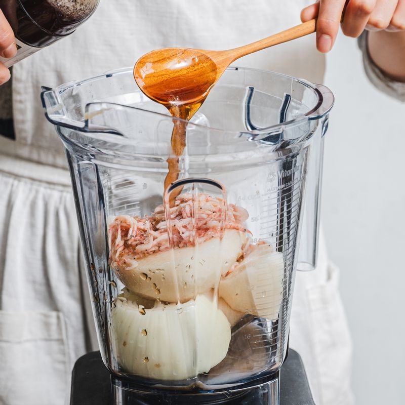 믹서에 갈아주는 양념 재료를 넣고 곱게 갈아주세요. 갈아 둔 양념에 고춧가루를 넣고 섞어주세요.