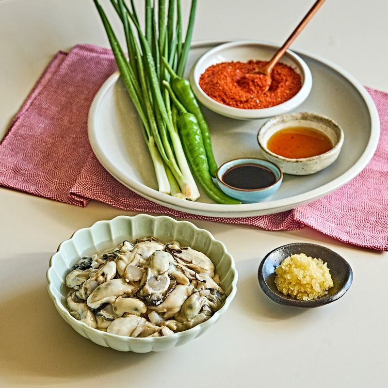 꽃굴무침을 위한 재료 이미지로 생굴,다진마늘,고춧가루,쪽파,청양고추 등으로 구성 되어있습니다.