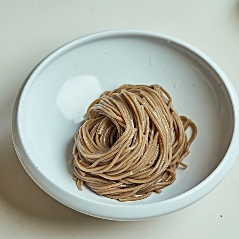 그릇에 삶은 면을 올리고 무, 오이, 낫또, 통깨를 올려주세요.