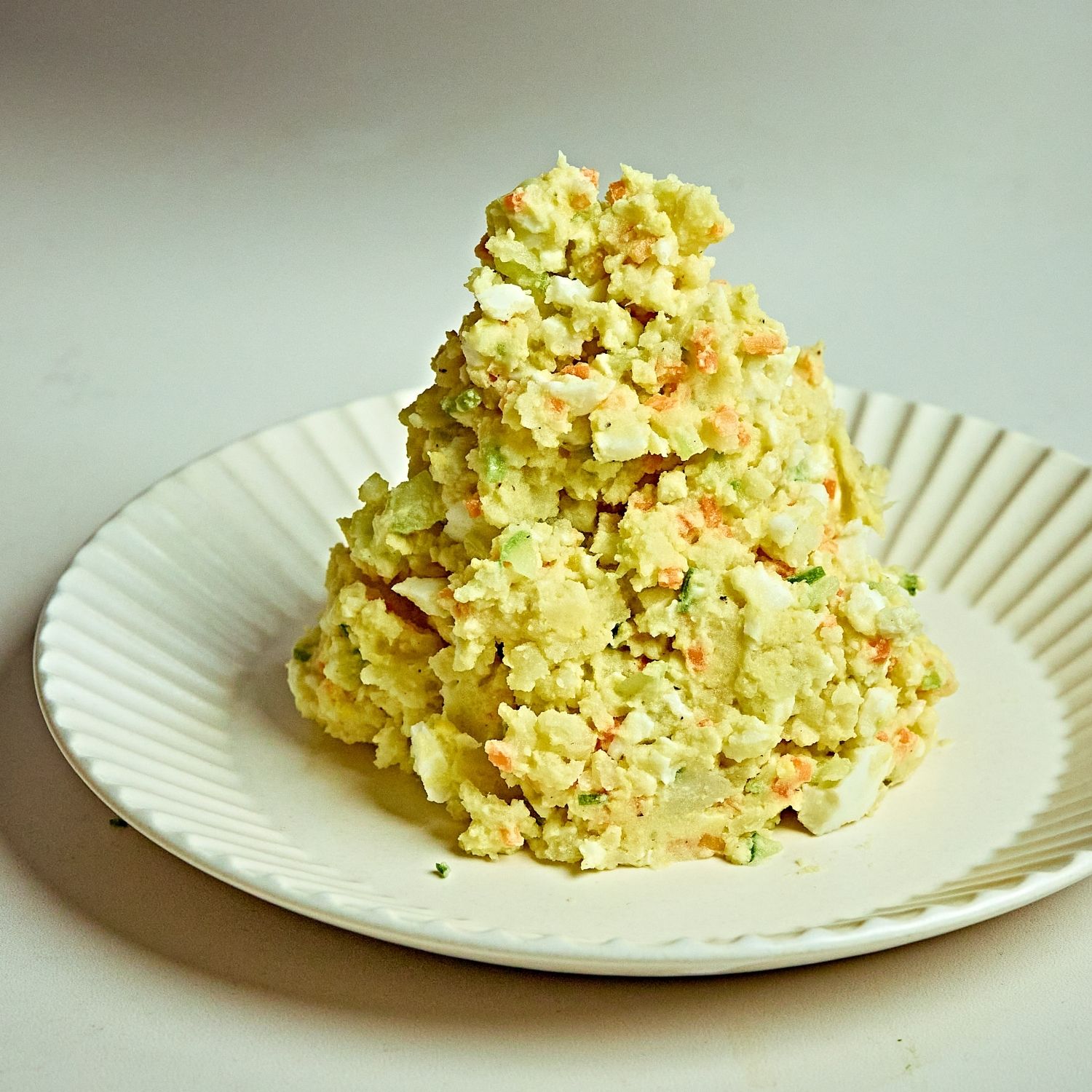 감자샐러드를 접시에 담고 우니소스를 뿌려 마무리하고 베이컨칩과 다진파슬리를 뿌려 주세요.